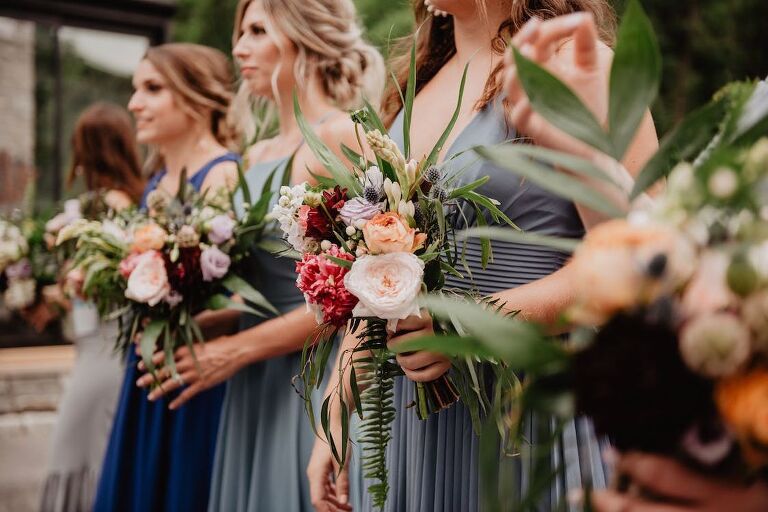 Bridesmaids lined up during a wedding ceremony while holding their flower bouquet