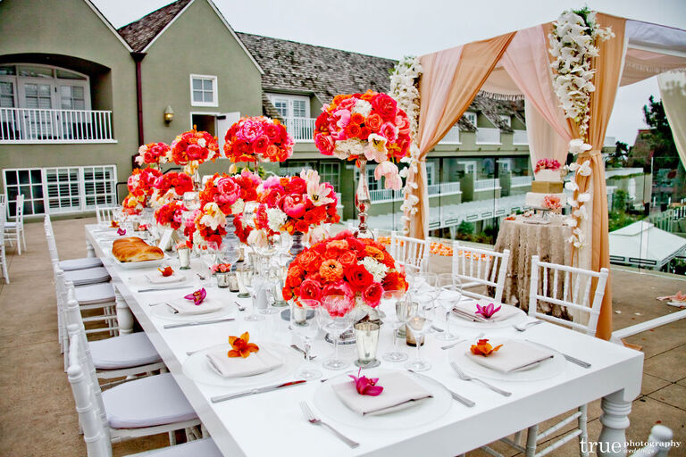 Orange and red flower arrangements placed at the center of a table