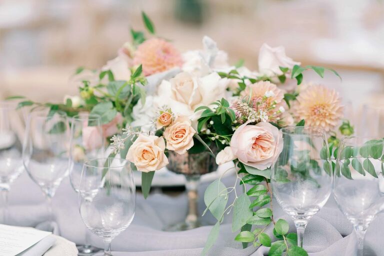 Peach and white roses as a center table flower arrangement in a wedding table