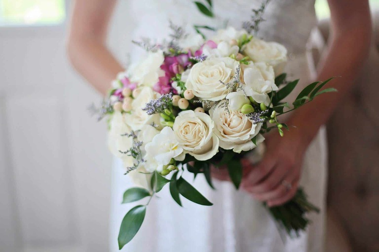 A bride holding a small yet elegant bouquet flowers